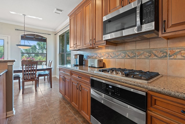 kitchen with light stone countertops, decorative backsplash, crown molding, appliances with stainless steel finishes, and light tile patterned floors