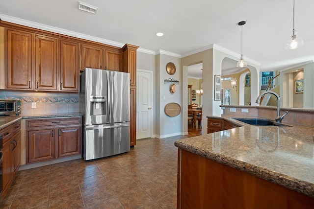 kitchen featuring tasteful backsplash, sink, dark stone counters, hanging light fixtures, and stainless steel fridge with ice dispenser