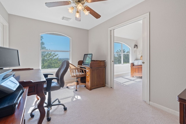 carpeted home office featuring ceiling fan