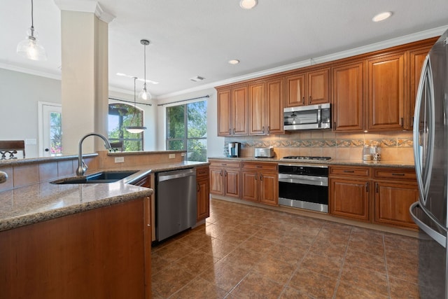 kitchen featuring tasteful backsplash, sink, ornamental molding, pendant lighting, and appliances with stainless steel finishes