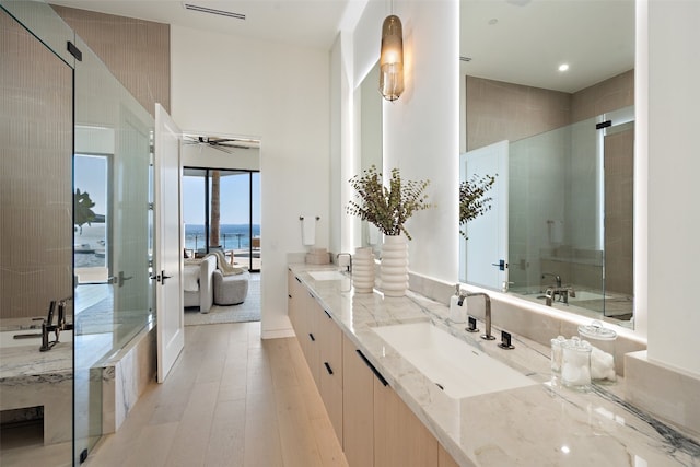 bathroom featuring a water view, a shower with shower door, vanity, and ceiling fan