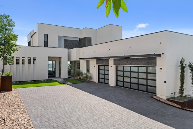 6809 Oasis Pass, Austin, TX 78732 - modern home featuring decorative driveway, a garage, and stucco siding