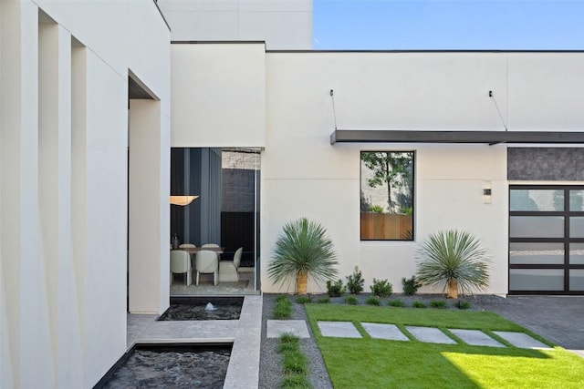 6809 Oasis Pass, Austin, TX 78732 - view of exterior entry featuring a yard and stucco siding