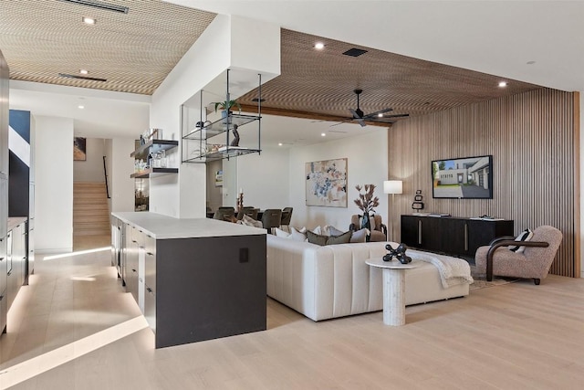 6809 Oasis Pass, Austin, TX 78732 - living area featuring light wood finished floors, a ceiling fan, recessed lighting, an accent wall, and stairway