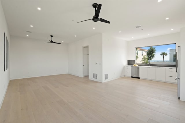 unfurnished living room featuring ceiling fan, sink, and light hardwood / wood-style floors