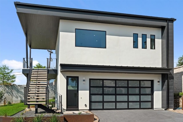 6809 Oasis Pass, Austin, TX 78732 - contemporary house featuring stairway, a garage, asphalt driveway, and stucco siding