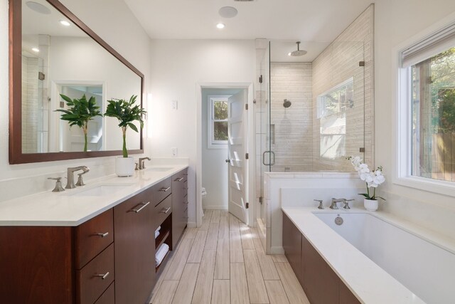 full bathroom with shower with separate bathtub, vanity, and toilet