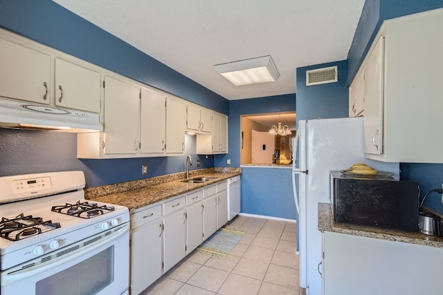 kitchen with sink, white appliances, white cabinetry, and decorative light fixtures