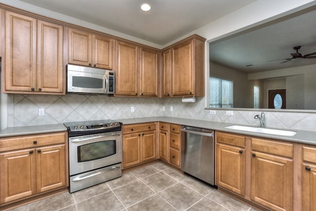 kitchen featuring appliances with stainless steel finishes, backsplash, sink, and tile patterned floors