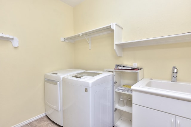 laundry room featuring cabinets, sink, light tile patterned floors, and washer and clothes dryer