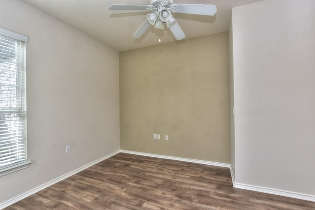 empty room featuring ceiling fan, a wealth of natural light, and dark hardwood / wood-style flooring