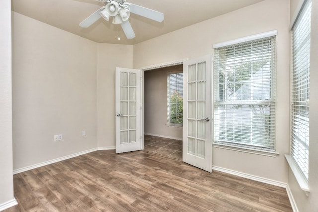 empty room featuring hardwood / wood-style floors, a healthy amount of sunlight, ceiling fan, and french doors