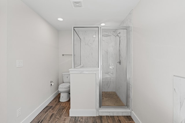 bathroom with wood-type flooring, toilet, and an enclosed shower