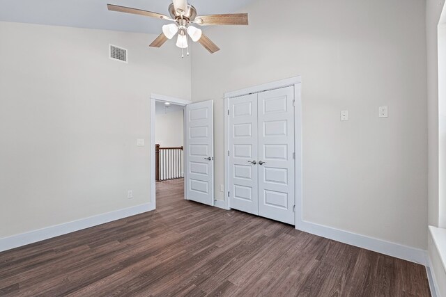 110 E Holland St, San Marcos, TX 78666 - unfurnished bedroom with a towering ceiling, dark wood finished floors, baseboards, a closet, and ceiling fan