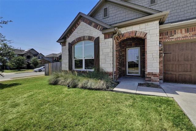 property entrance featuring stone siding, brick siding, and a lawn