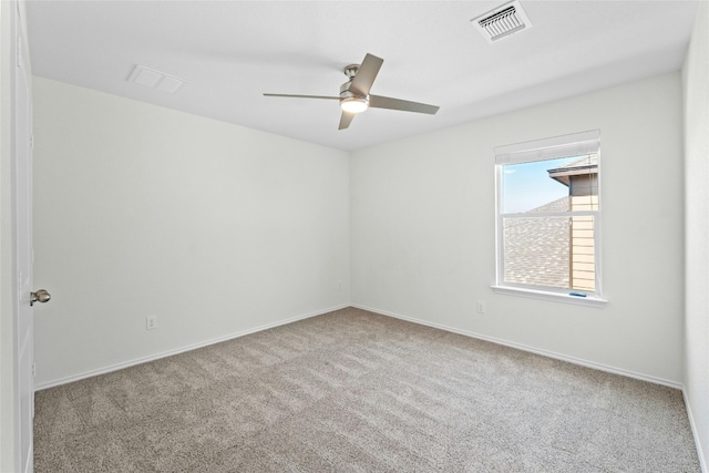 carpeted empty room with baseboards, visible vents, and a ceiling fan