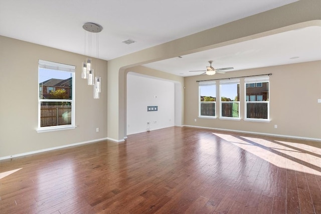 spare room featuring wood finished floors, visible vents, and baseboards