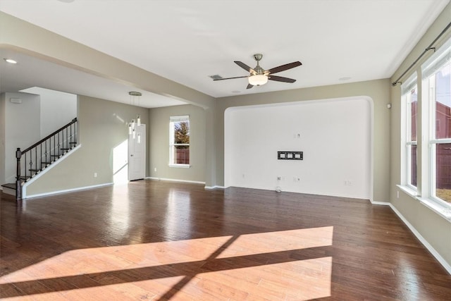 unfurnished living room featuring visible vents, ceiling fan, wood finished floors, baseboards, and stairs