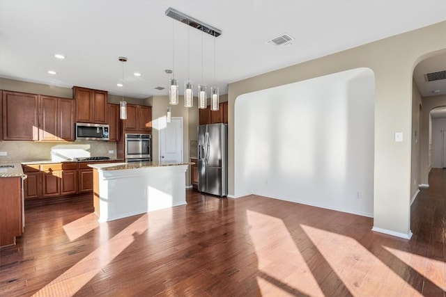 kitchen with arched walkways, stainless steel appliances, dark wood finished floors, and visible vents