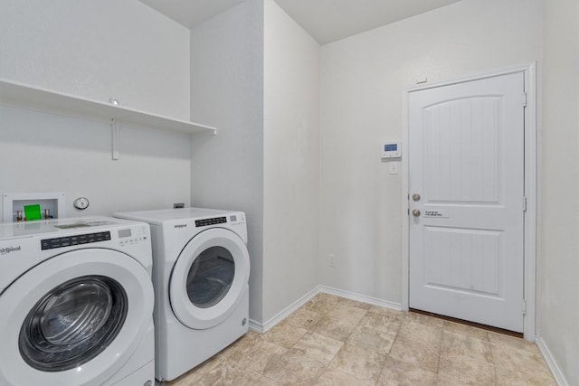 washroom featuring laundry area, washing machine and dryer, and baseboards