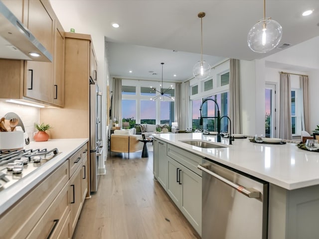 kitchen featuring hanging light fixtures, appliances with stainless steel finishes, sink, and a spacious island