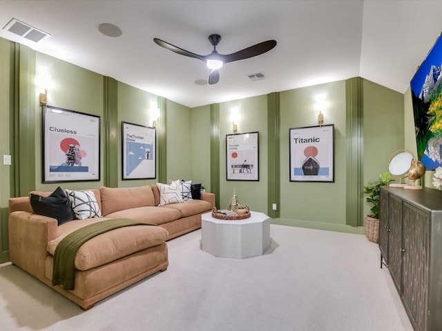 carpeted home theater room with vaulted ceiling and ceiling fan