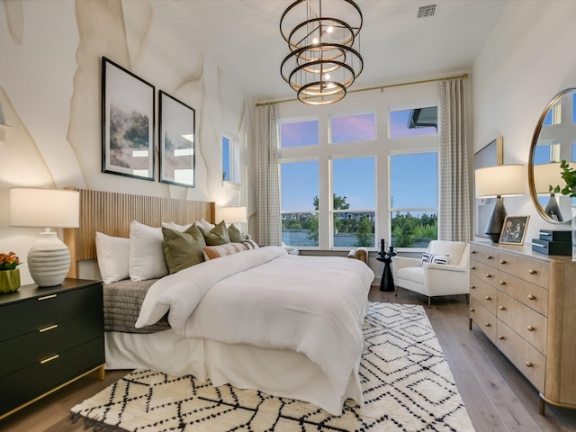 bedroom featuring hardwood / wood-style flooring and a chandelier