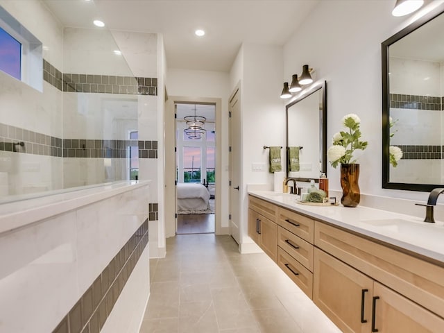 bathroom with vanity, a chandelier, tile patterned flooring, and tiled shower