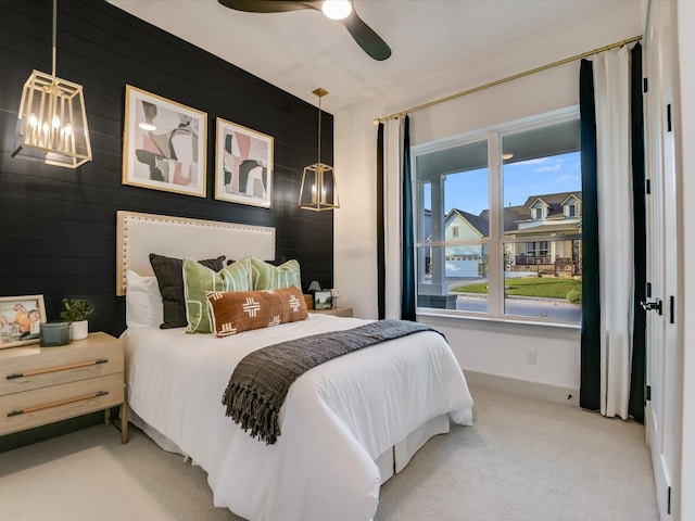 bedroom with carpet, wooden walls, and ceiling fan