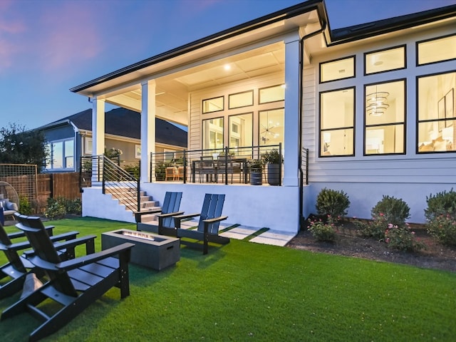 back house at dusk featuring a yard