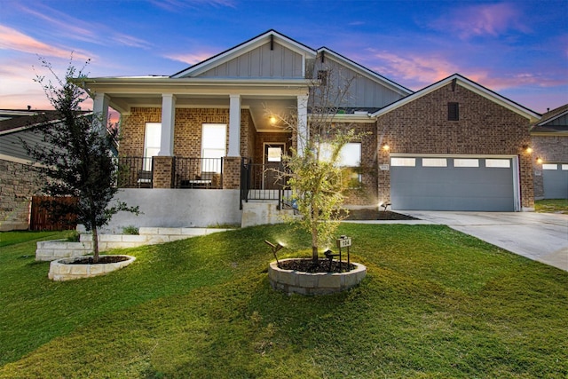 view of front of house with a yard, a garage, and covered porch