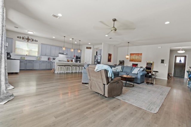 living room featuring light hardwood / wood-style flooring and ceiling fan