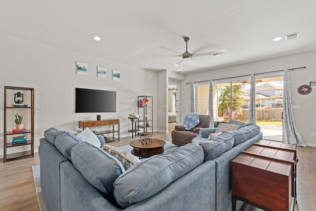 living room with light wood-type flooring and ceiling fan