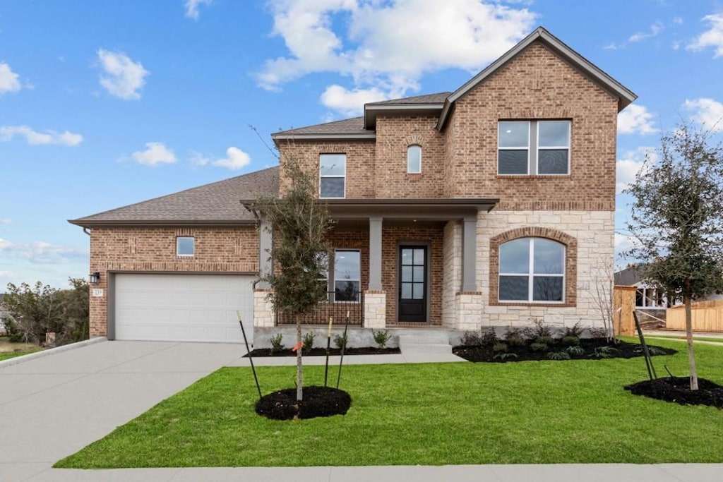 733 Teakmill Trl, San Marcos, TX 78666 - view of front facade with brick siding, concrete driveway, and a front lawn