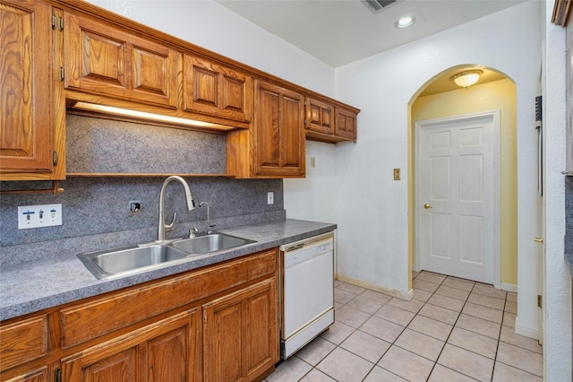 kitchen with decorative backsplash, sink, white dishwasher, and light tile patterned floors