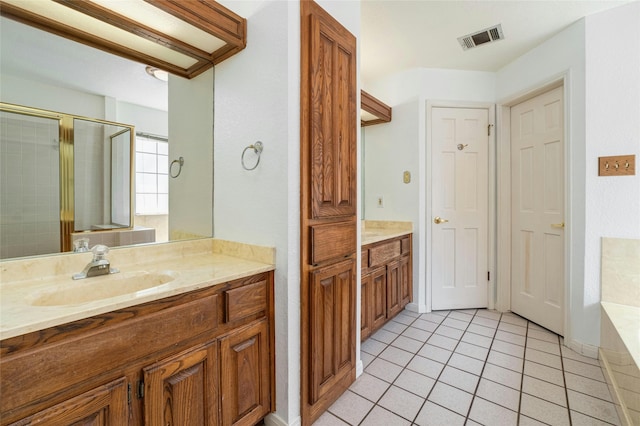 bathroom with tile patterned flooring, vanity, and a shower with door