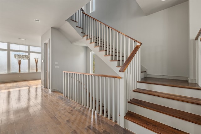 stairs featuring a chandelier and hardwood / wood-style flooring