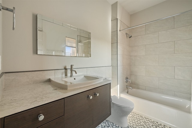 full bathroom featuring tile patterned floors, vanity, toilet, and tiled shower / bath combo