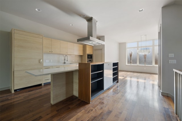 kitchen featuring dark wood-type flooring, island exhaust hood, a kitchen island, and sink