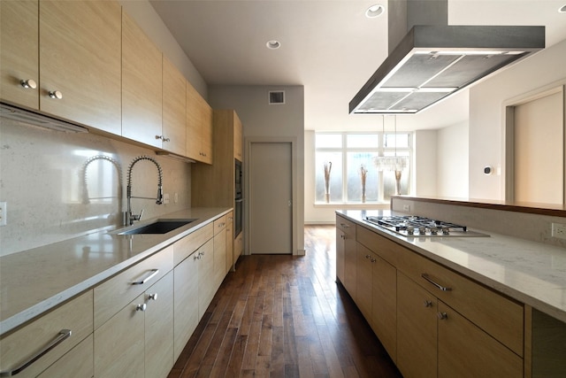 kitchen featuring stainless steel gas cooktop, sink, light stone counters, dark hardwood / wood-style flooring, and exhaust hood