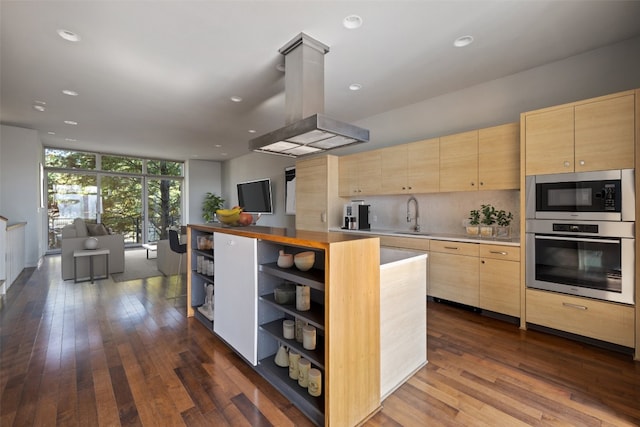 kitchen with sink, decorative columns, dark hardwood / wood-style floors, light brown cabinets, and appliances with stainless steel finishes