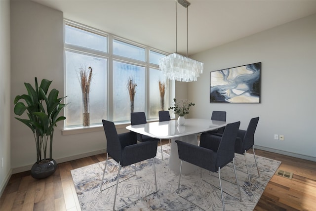 dining area featuring hardwood / wood-style floors and a chandelier