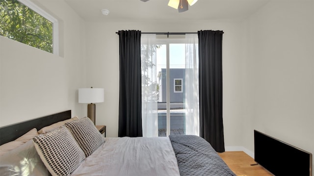 bedroom with light wood-style flooring, baseboards, and a ceiling fan
