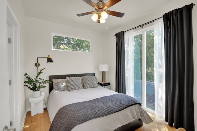 bedroom with light wood finished floors, baseboards, and ceiling fan