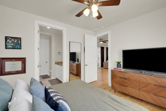bedroom with light wood-type flooring, baseboards, ceiling fan, and connected bathroom