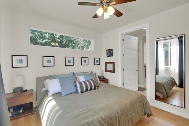 bedroom with light wood-type flooring, baseboards, and ceiling fan