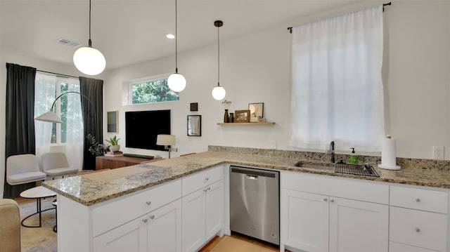 kitchen with white cabinets, visible vents, stainless steel dishwasher, a sink, and a peninsula