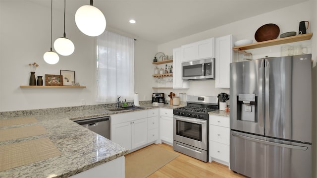 kitchen with open shelves, white cabinetry, stainless steel appliances, and a sink
