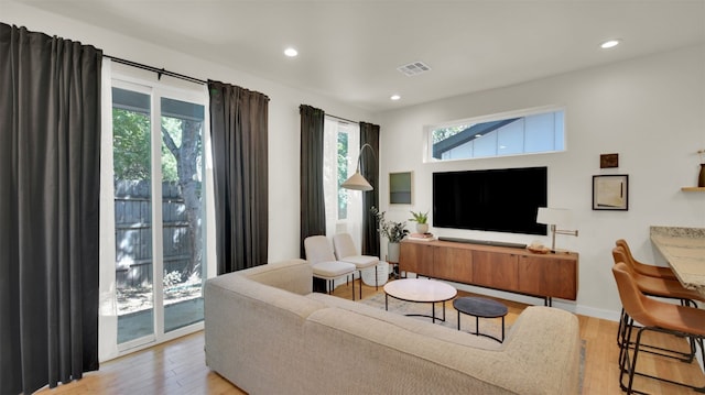 living area featuring light wood finished floors, visible vents, and a wealth of natural light