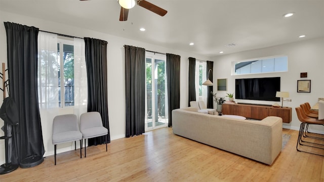 living room featuring ceiling fan and light wood-type flooring